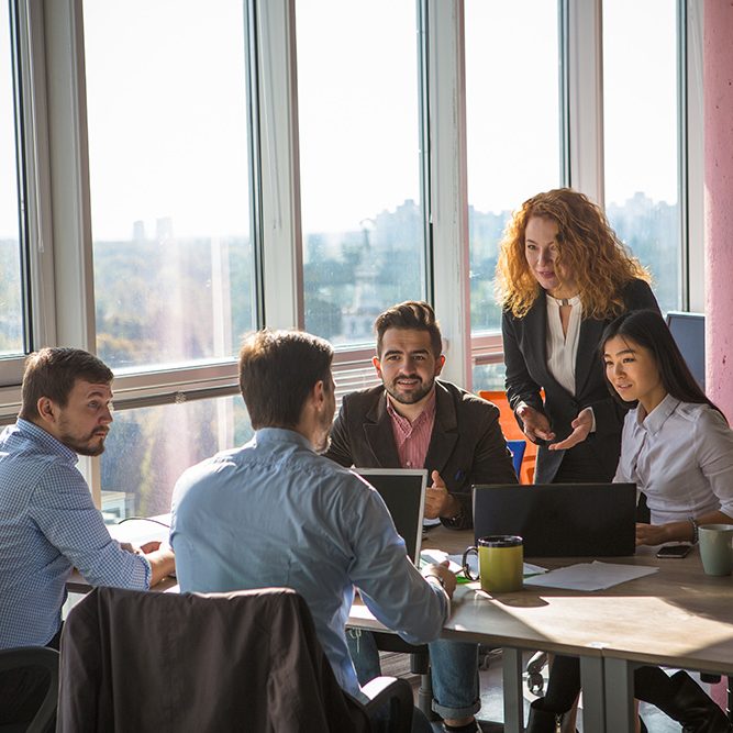 Business people listening to one of their colleague bad or good news for their company, enterprise or firm while working round table in board room in office.